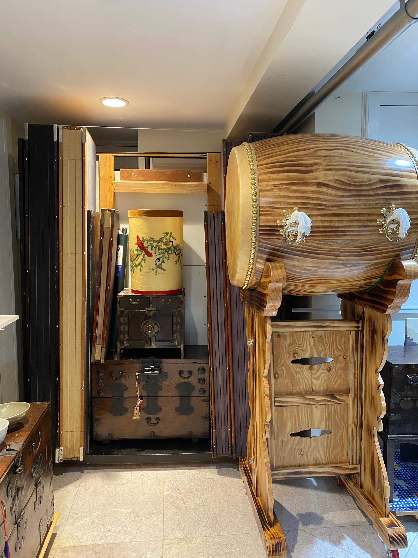 Large traditional Korean drum beside antique chests in the museum